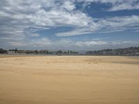 a lone beach with waves coming in and blue skies and clouds above it are not visible, but in this image