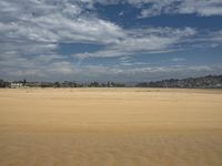 a lone beach with waves coming in and blue skies and clouds above it are not visible, but in this image