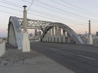 a metal bridge crosses over a busy road near some buildings and a street light in the foreground