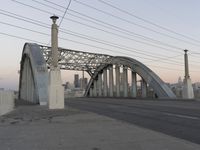 a metal bridge crosses over a busy road near some buildings and a street light in the foreground