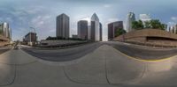 a fisheye lens showing a skateboard on a road with tall buildings behind it