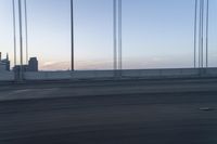 a city from a freeway driving over a bridge under construction in the sun set with clouds