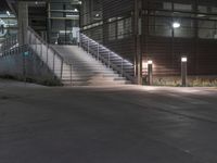 a lighted walkway outside a building with stairs on either side and stairs above the doorway