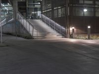 a lighted walkway outside a building with stairs on either side and stairs above the doorway