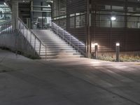 a lighted walkway outside a building with stairs on either side and stairs above the doorway
