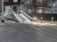 a lighted walkway outside a building with stairs on either side and stairs above the doorway