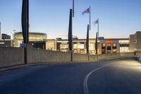 empty street with concrete fence and traffic lights in the dark at twilight time with a street lamp on pole