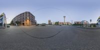 a spherical image of a street with buildings and a lamp post on either side of a circle