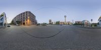 a spherical image of a street with buildings and a lamp post on either side of a circle