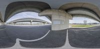 a fish eye lens of a street with overpasses and overpasss in the background