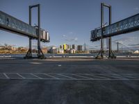 empty parking lot with view of the skyline and bridge in distance below in daylight with blue sky