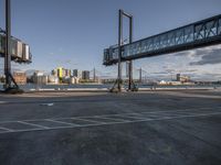 empty parking lot with view of the skyline and bridge in distance below in daylight with blue sky