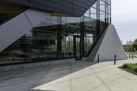 the building has glass and has an outside patio area with stone steps to the floor