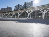 a bus stop sitting by itself on a large sidewalk near tall buildings in the city