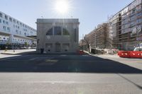 a large building is under construction in the middle of town on the right of the street