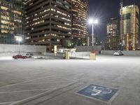 an empty parking lot at night surrounded by buildings and cars in a parking area at a business district