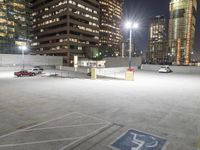 an empty parking lot at night surrounded by buildings and cars in a parking area at a business district