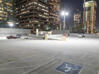 an empty parking lot at night surrounded by buildings and cars in a parking area at a business district