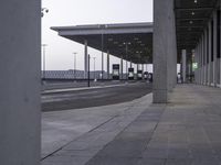 there is a view of an airport terminal from the outside, with some buses parked behind them