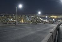 a view from the top of a bridge of a freeway and city lights over a city