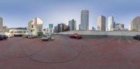 there is a 360 - angle photograph of cars parked in a parking lot next to a tall skyscraper