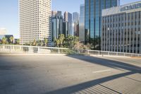 a paved street is in the city near tall buildings and trees on the side of the road