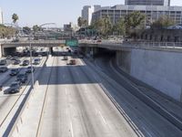 the view of a highway and a street from the freeway bridge above it with several cars on it