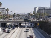 the view of a highway and a street from the freeway bridge above it with several cars on it