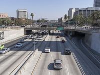 the view of a highway and a street from the freeway bridge above it with several cars on it