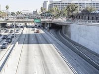 the view of a highway and a street from the freeway bridge above it with several cars on it