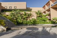 an open courtyard with a water feature and many palm trees beside the swimming area in a hotel building