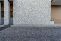 the door of a brick building is painted white with speckles and bricks in various colors