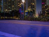 city street in front of tall buildings at dusk with one light on it's corner