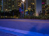 city street in front of tall buildings at dusk with one light on it's corner