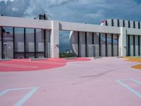 the outside view of an open - air shopping center with painted parking spots on red and yellow surfaces