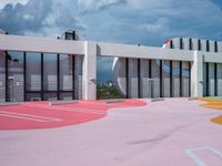 the outside view of an open - air shopping center with painted parking spots on red and yellow surfaces