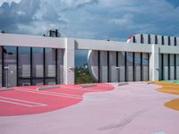 the outside view of an open - air shopping center with painted parking spots on red and yellow surfaces