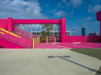 a pink building with staircases and yellow railing on the outside area of the building