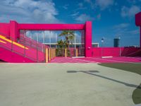 a pink building with staircases and yellow railing on the outside area of the building