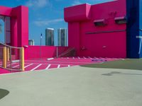 the court outside is in a pink building and blue is bright pink with white paint