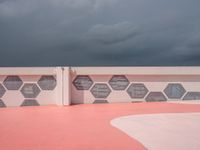 this is the end of a pink wall with colorful hexagons painted on it