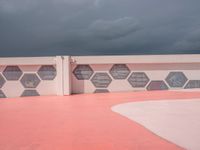 this is the end of a pink wall with colorful hexagons painted on it