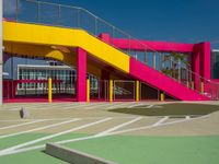 a view of a modern outdoor tennis court with stairs, railings and courtside