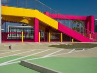 a view of a modern outdoor tennis court with stairs, railings and courtside