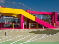 a view of a modern outdoor tennis court with stairs, railings and courtside