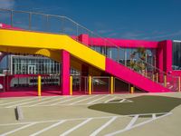 a view of a modern outdoor tennis court with stairs, railings and courtside