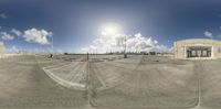 a panoramic photo of the building in a parking lot with its reflection in the lens