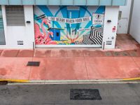 the entrance to an ice cream shop with a mural on the outside wall of it