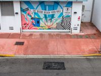 the entrance to an ice cream shop with a mural on the outside wall of it