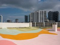 colorful playground on the rooftop with urban buildings in the background and a street sign at one end